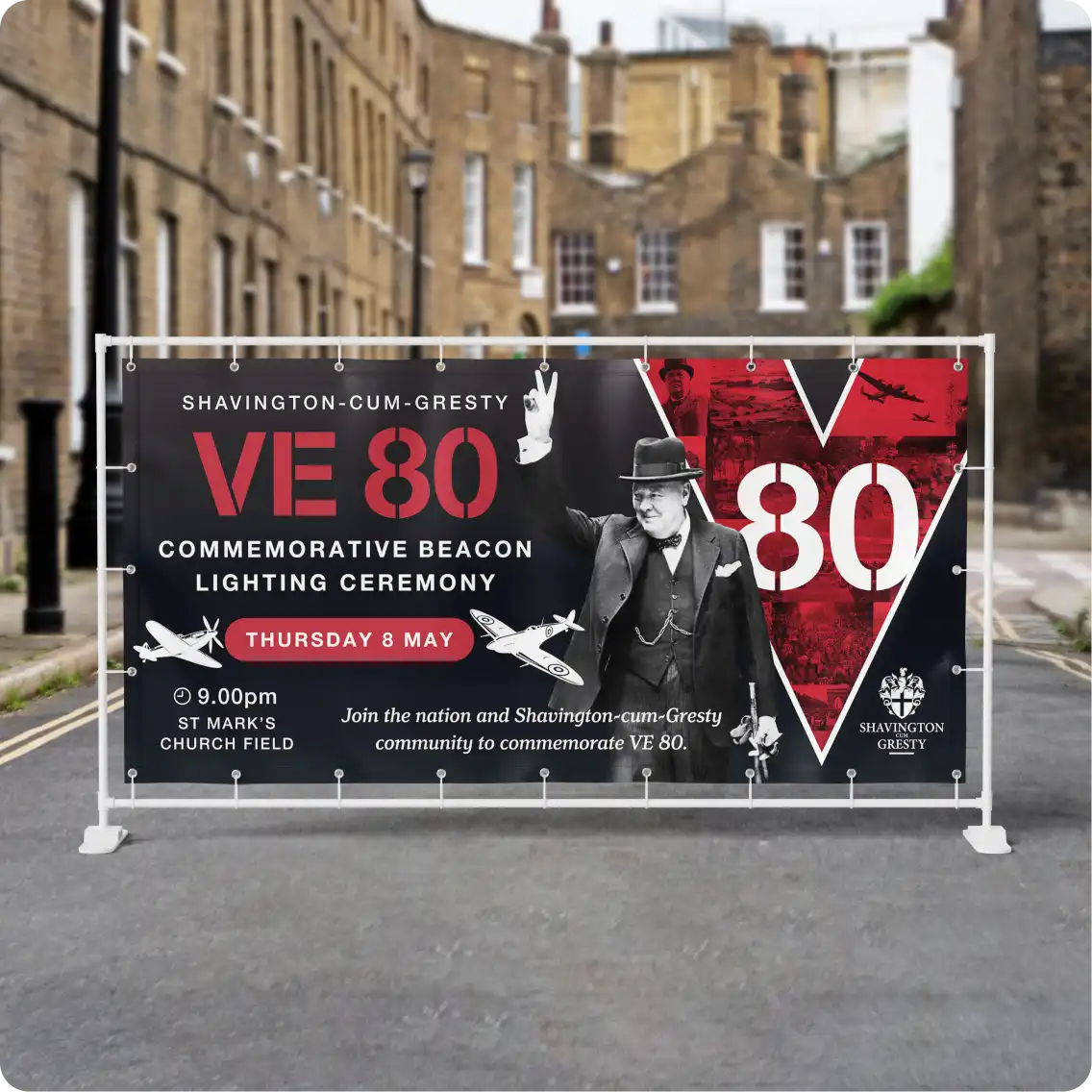 A vinyl banner advertising the Shavington VE80 beacon lightin ceremony in a street